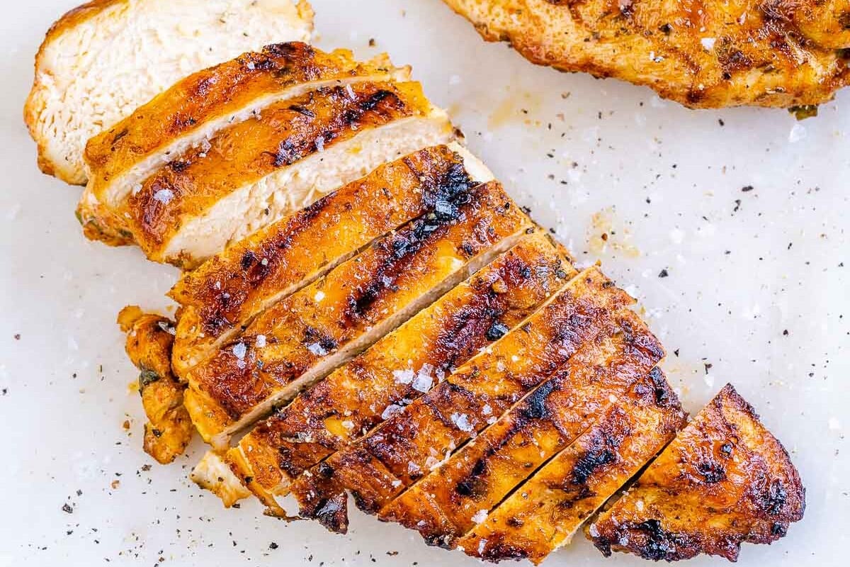 sliced grilled chicken breast on a cutting board.