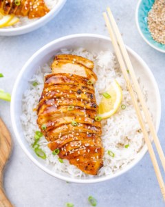 top view sliced teriyaki chicken breast over a bowl of rice