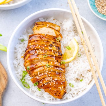top view sliced teriyaki chicken breast over a bowl of rice