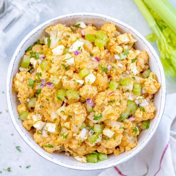 cauliflower salad with chopped eggs in a white bowl.