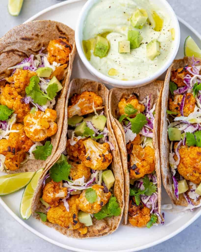 side shot of veggie tacos in a white plate 