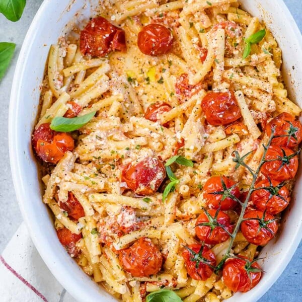 top view tomato and feta cheese pasta on a white dish with roasted tomatoes