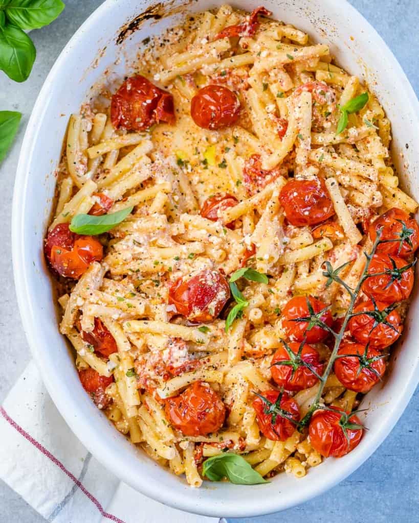 top view tomato and feta cheese pasta on a white dish with roasted tomatoes
