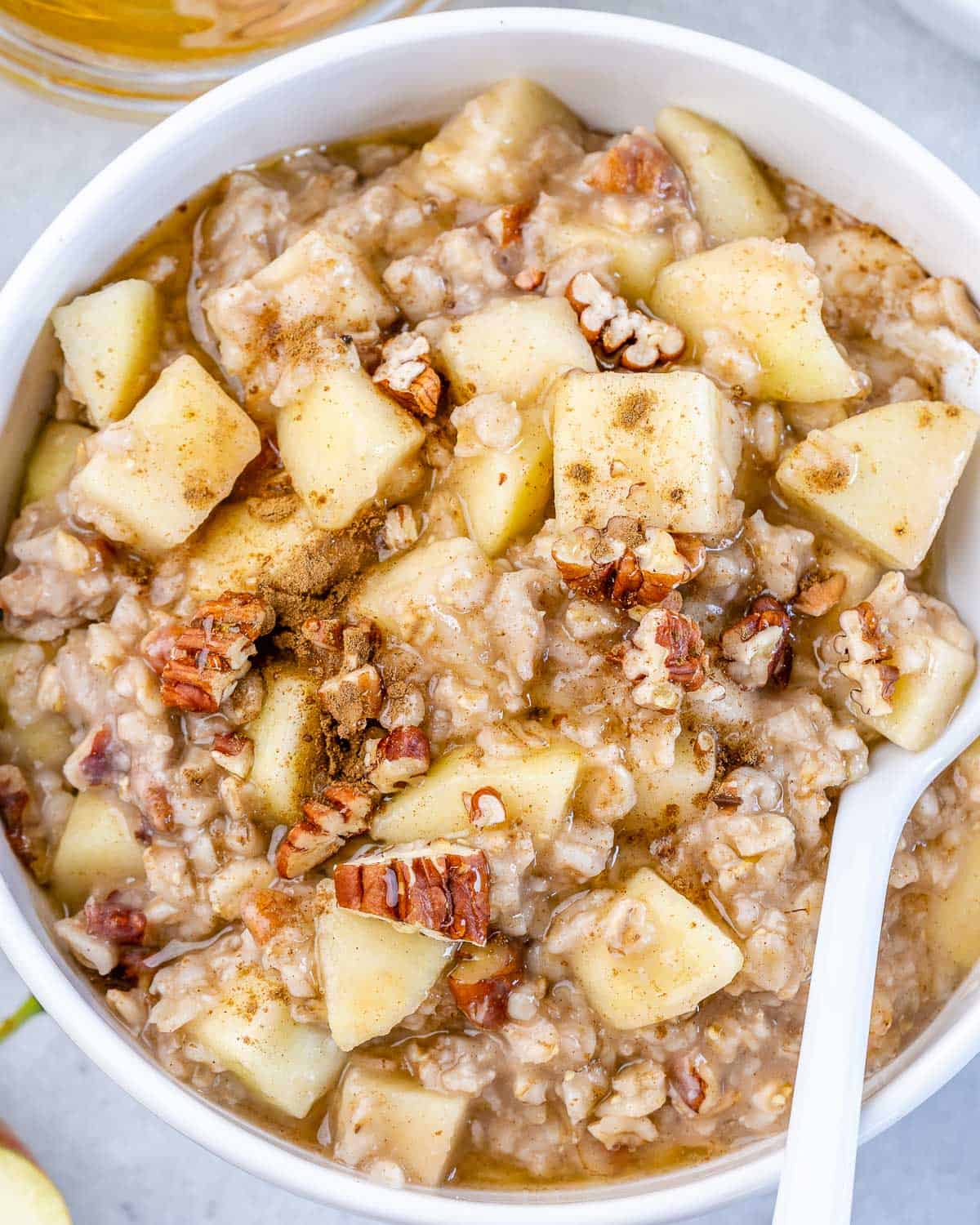 close up apple oatmeal bowl with spoon in it