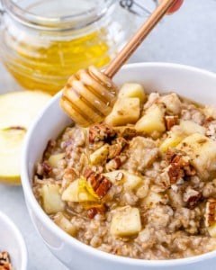 honey being drizzled over an oatmeal bowl.