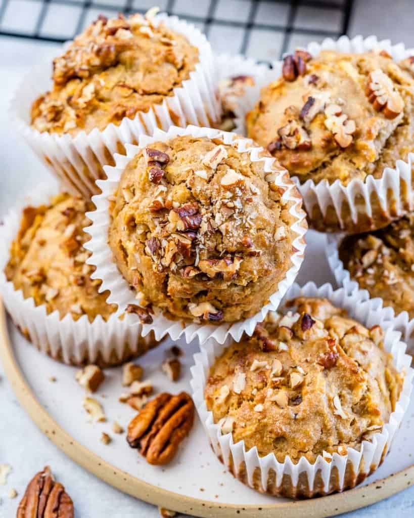 side shot of apple muffins stacked over each other on a plate