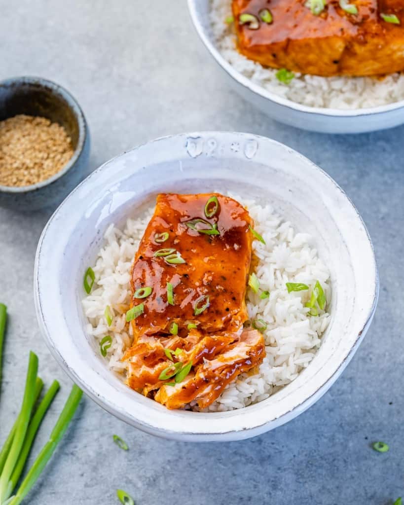 side shot of seared salmon over rice in a bowl