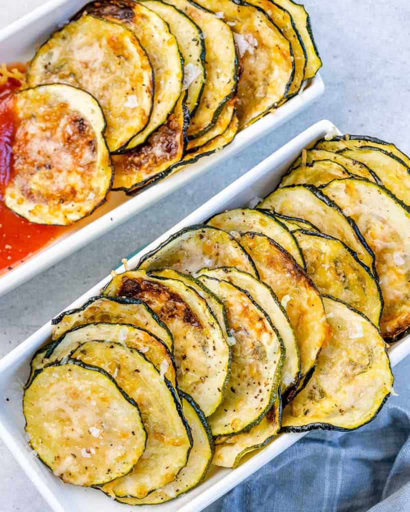 top view or zucchini chips lined in a white dish 