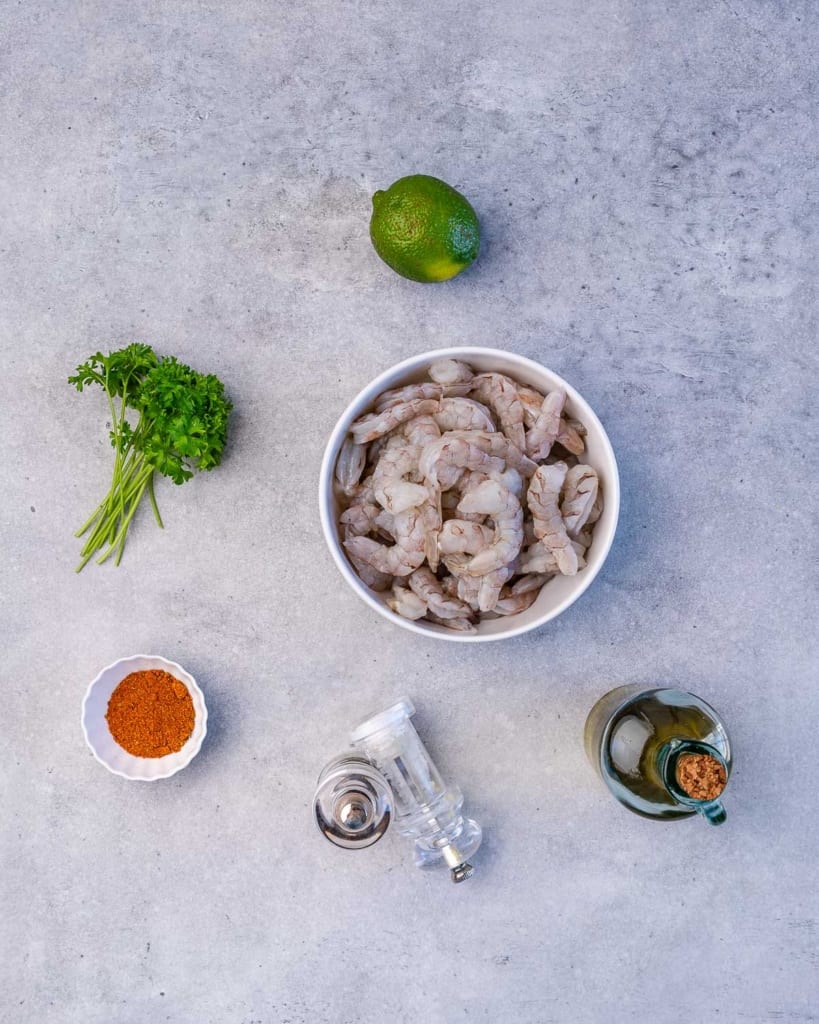 ingredients to make cajun shrimp on a flat gray surface 