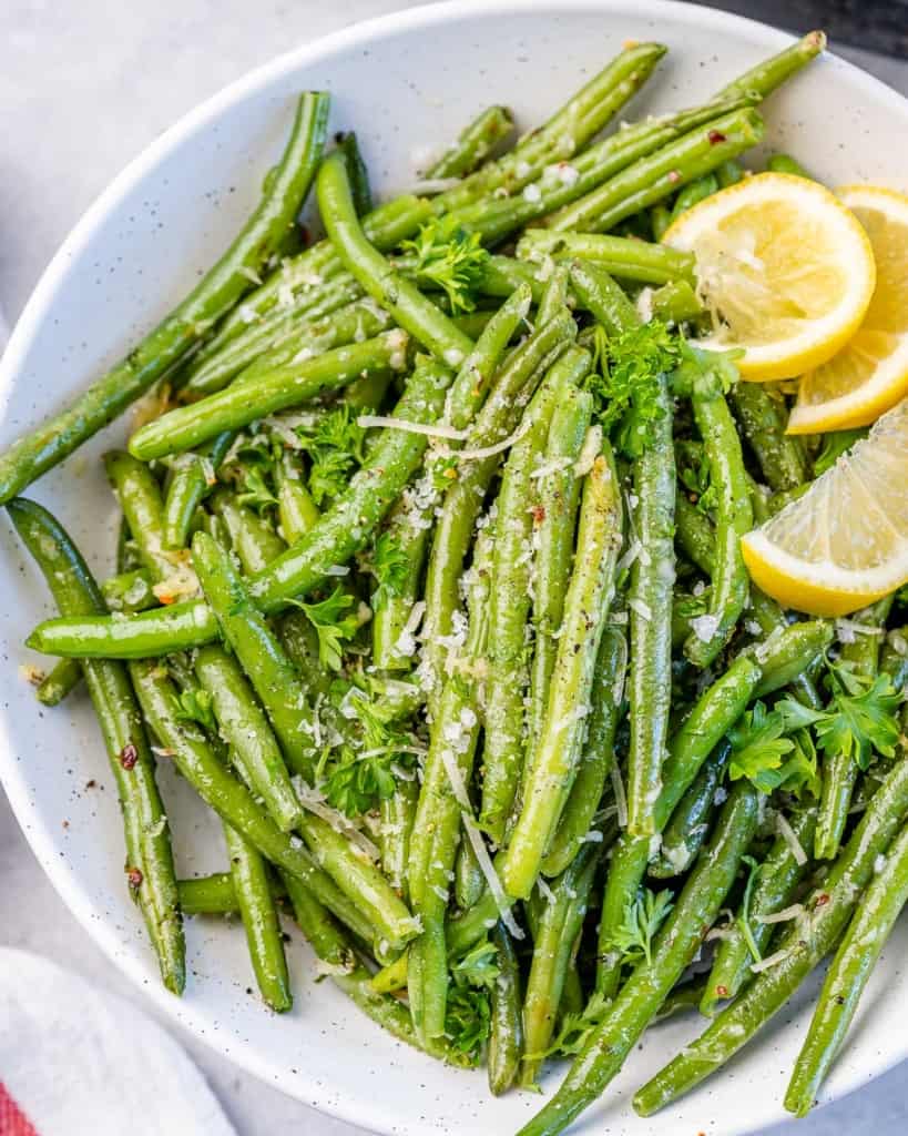 top view green beans on a plate with lemon garnishes