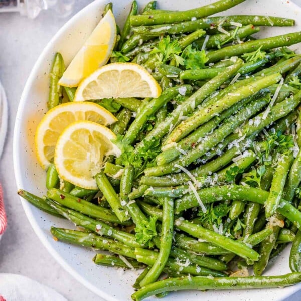 top view or roasted green beans topped with parmesan cheese and lemon garnishes