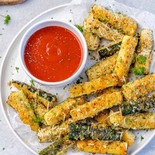 top view zucchini fries on a white plate with a side of ketchup