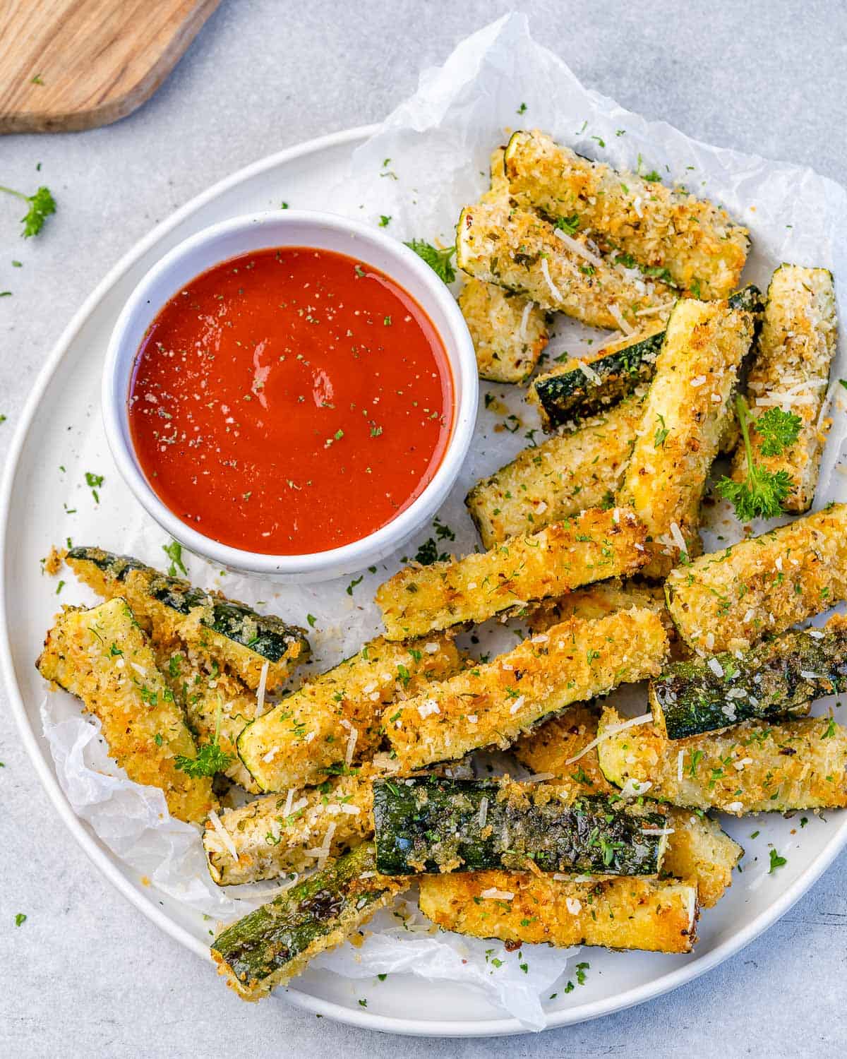 top view zucchini fries on a white plate with a side of ketchup