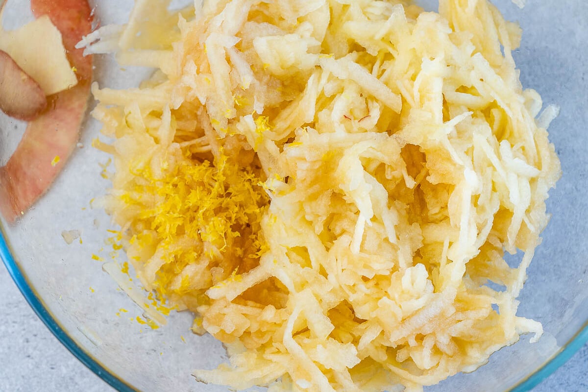 shredded apples and grated lemon in a bowl.