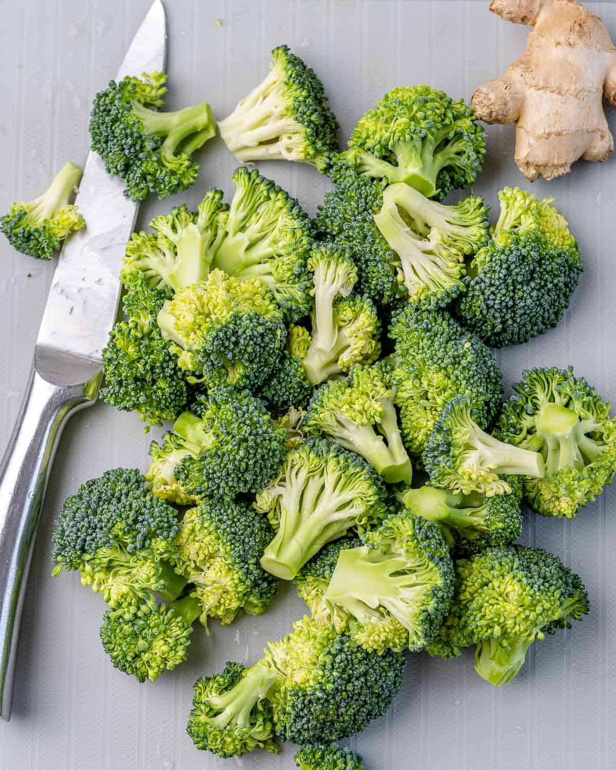 freshly chopped broccoli with knife on cutting board