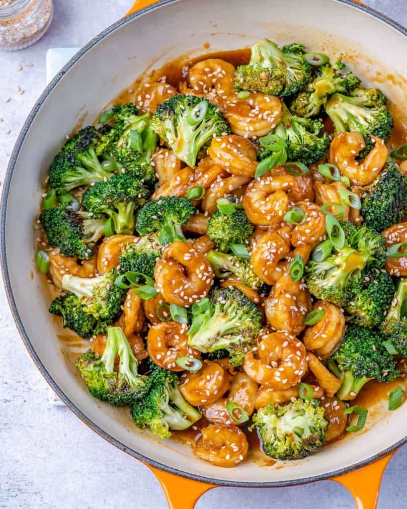 cooked shrimp and broccoli in skillet with sesame seeds and green onions