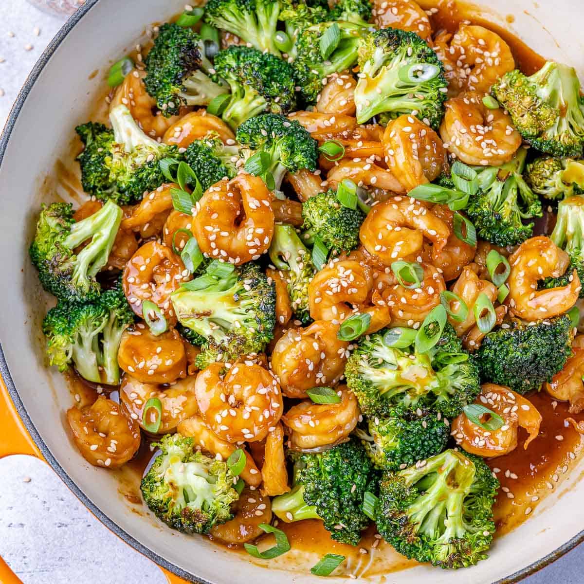 top view shrimp and broccoli stir fry in an orange skillet