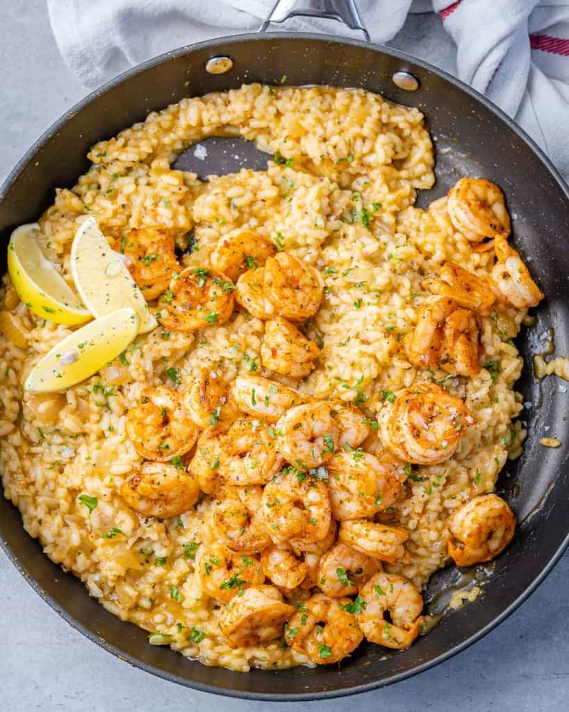 top view of shrimp and rice risotto in a black skillet