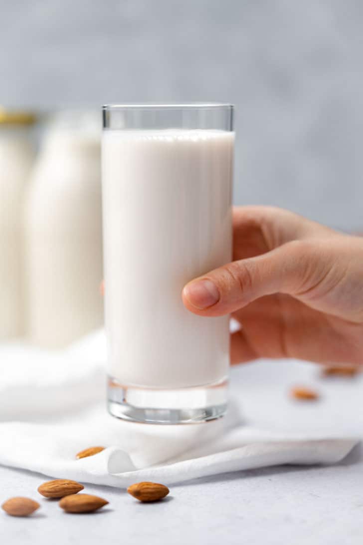 glass of almond milk with hand