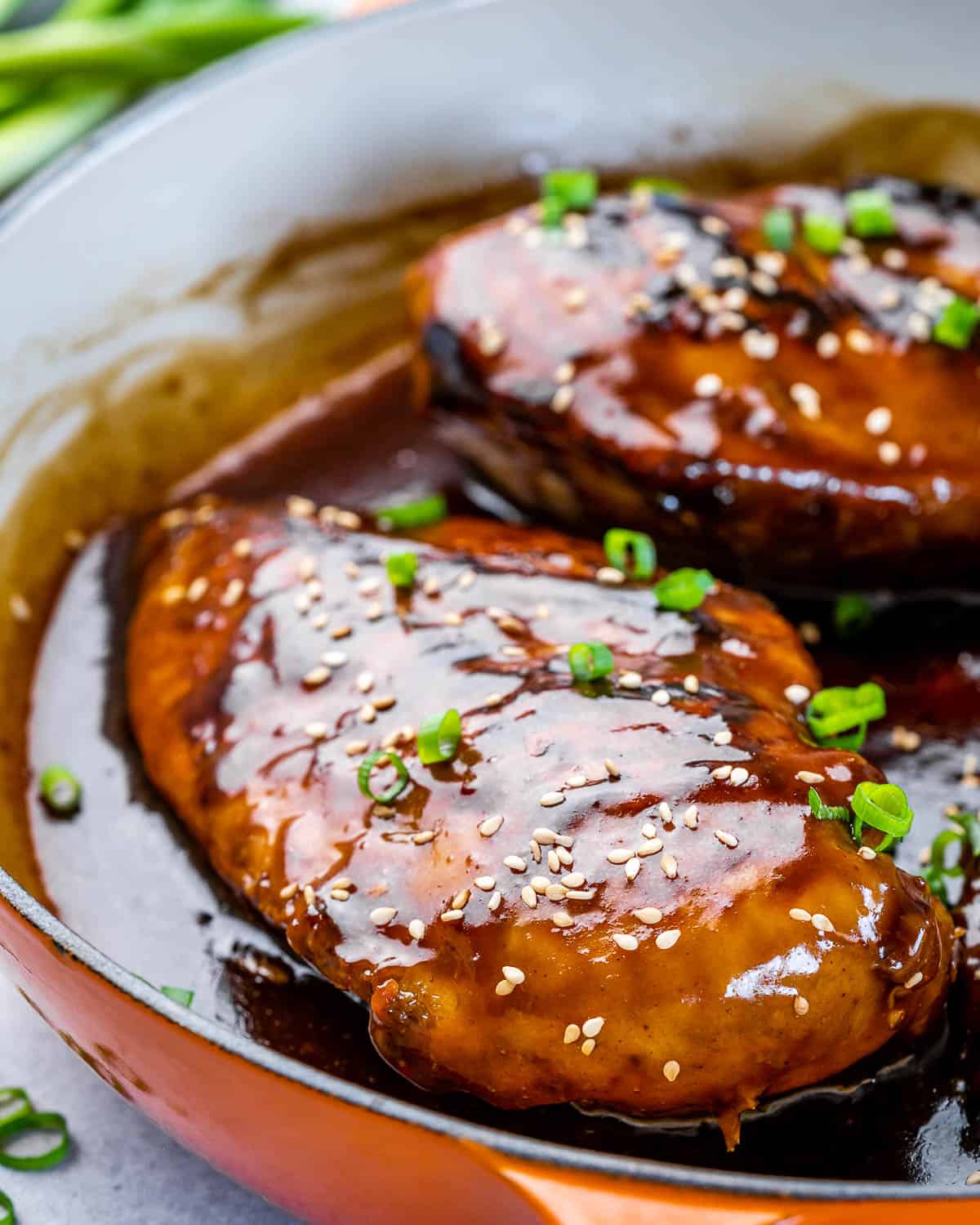 close view of Asian chili chicken breasts in pan with sweet and spicy sauce 
