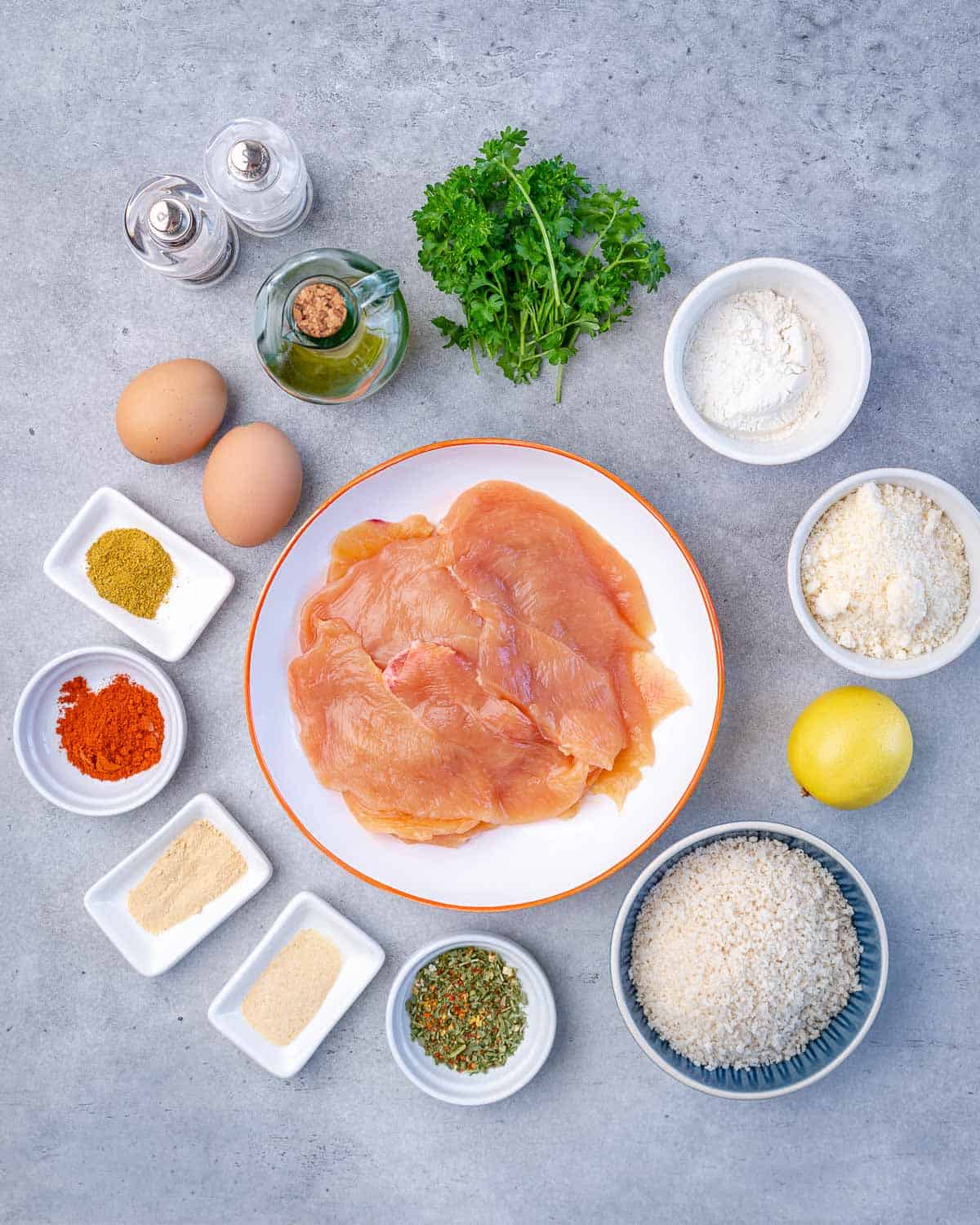 chicken, parsley, flour, salt, eggs, oil, pepper, celery salt, paprika, Italian seasoning, onion powder, garlic powder, parmesan, lemon 