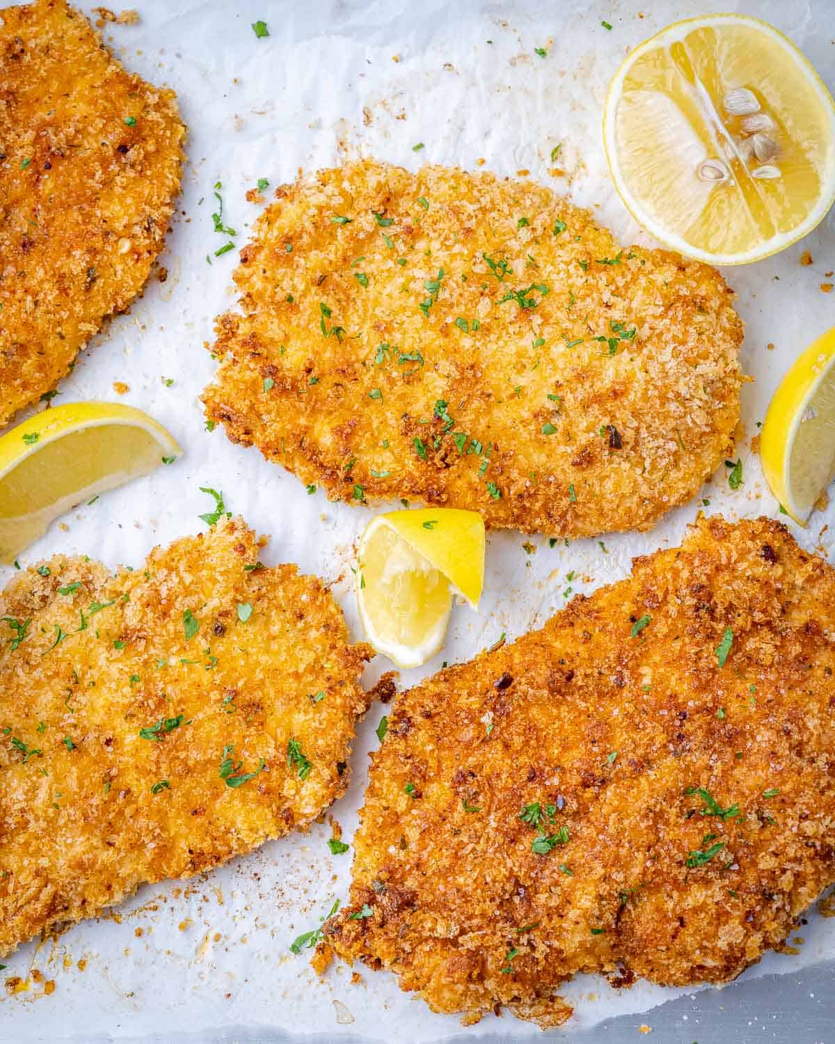 chicken cutlets with breadcrumb parmesan coating with lemon wedges