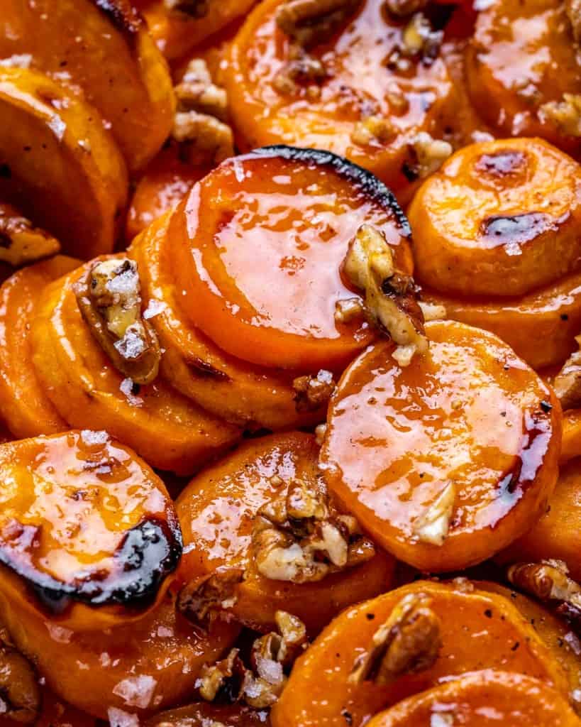 close up caramelized sliced sweet potatoes with pecans 