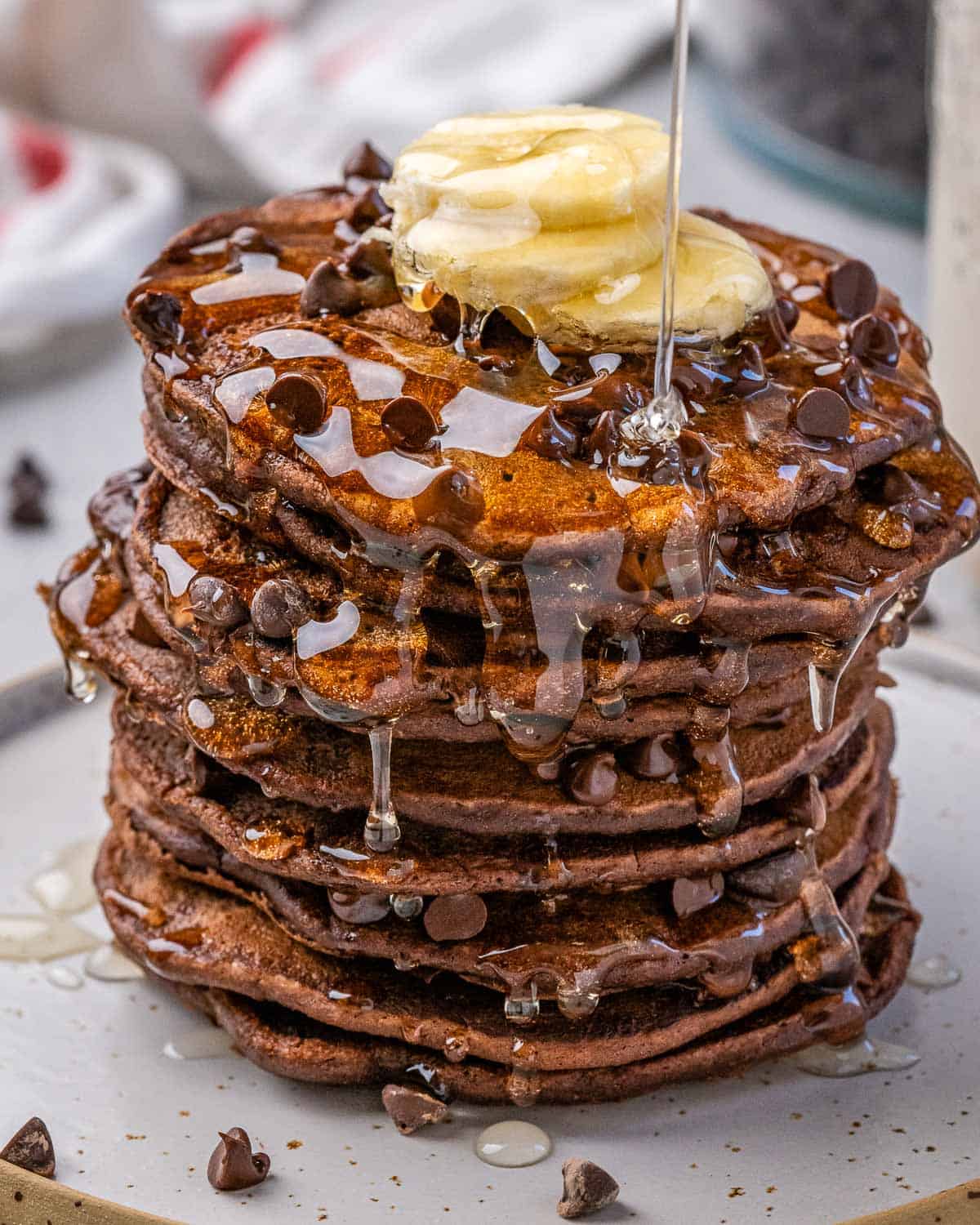 one stack of chocolate oat pancakes with banana and syrup