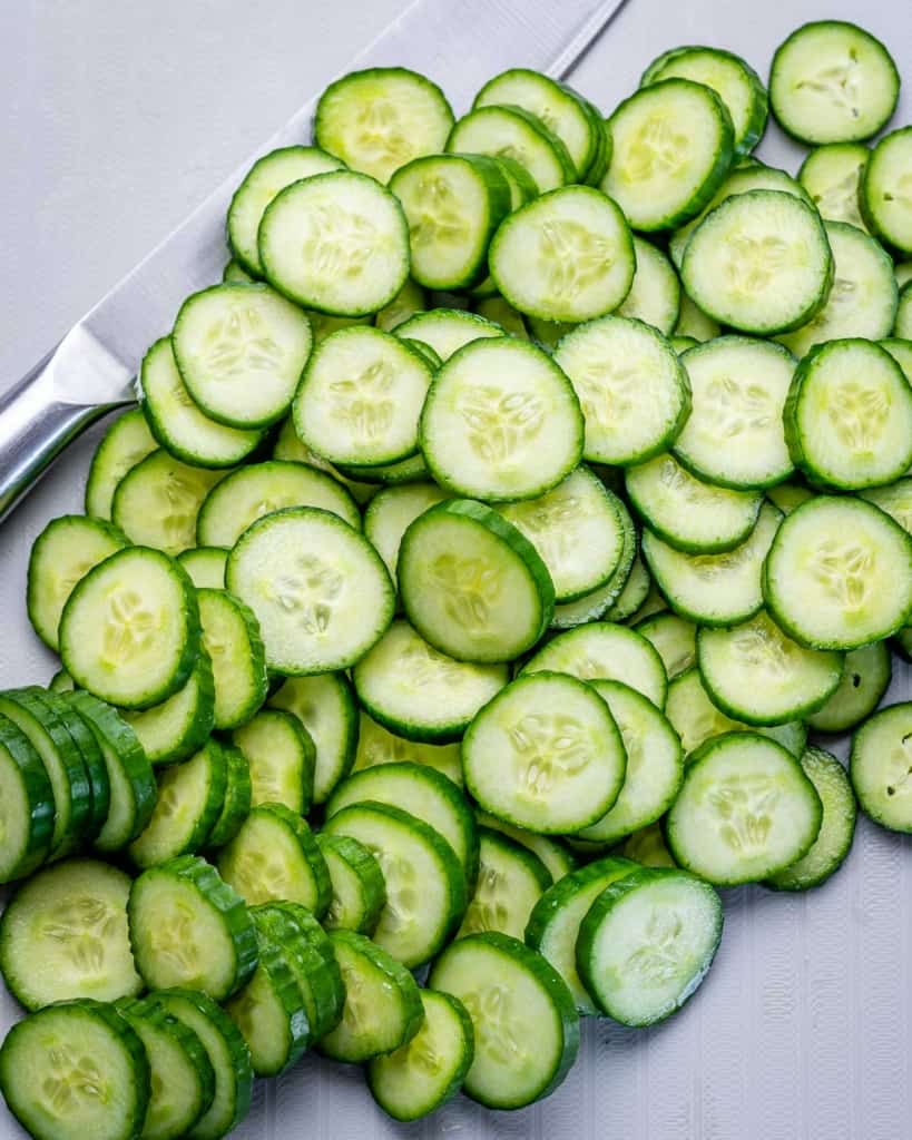 freshly sliced cucumbers on a cutting board