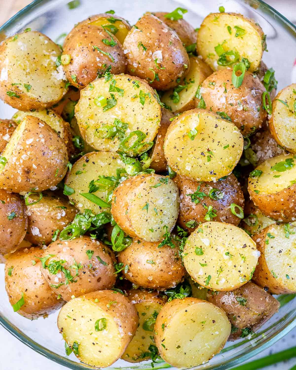 cooked red potatoes with parsley, salt, pepper, seasoning, and green onions 