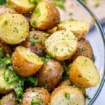 close view of cooked potatoes with herbs, salt, seasoning, green onions