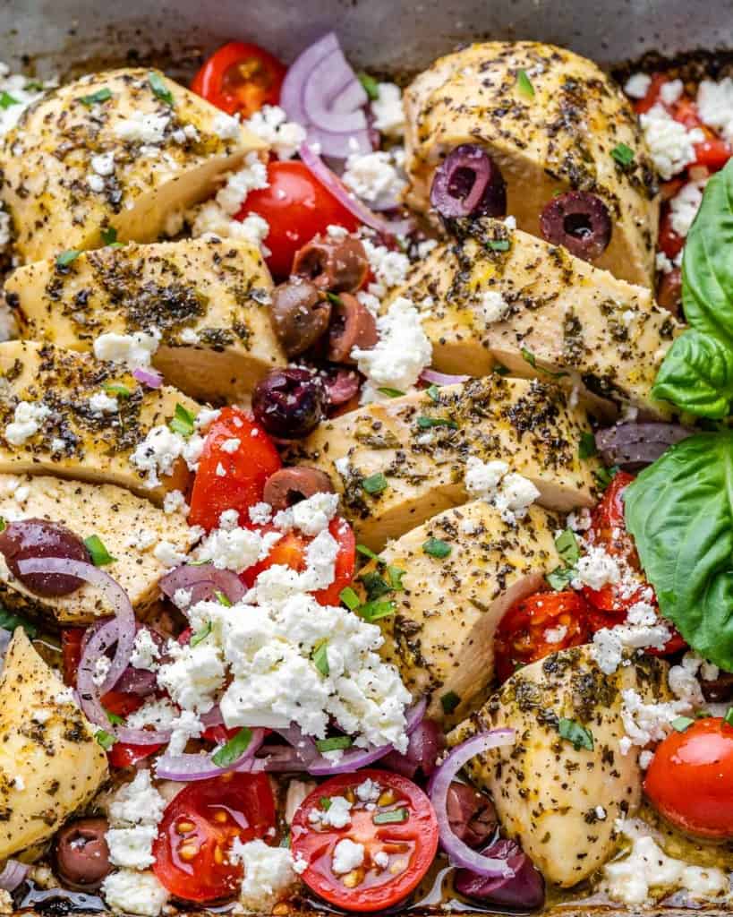 top view greek style baked chicken breast in white dish