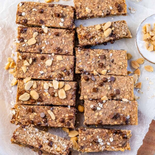 twelve baked oatmeal bars with chocolate chips and peanuts on parchment paper.