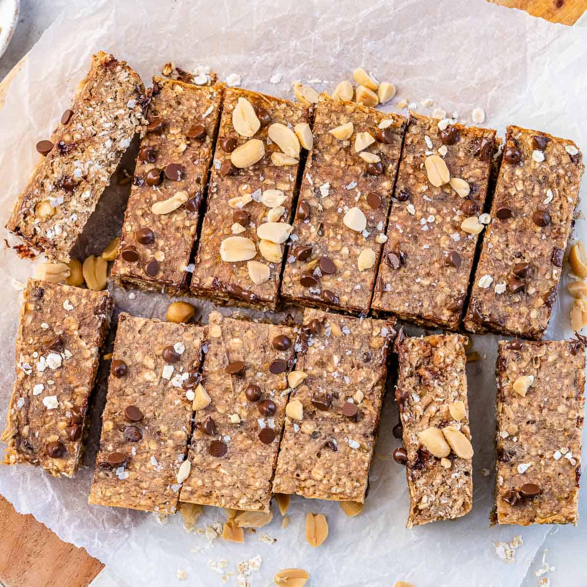 top view of oatmeal bar squares topped with peanuts on a parchment paper