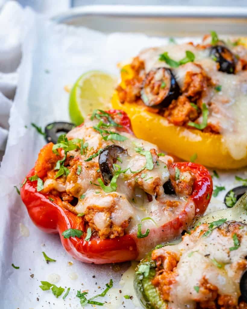 side shot of stuffed belle peppers topped with melted cheese
