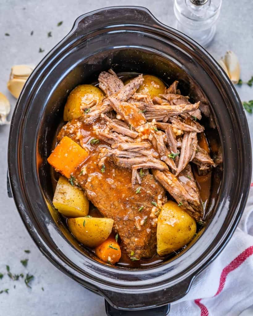 top view pot roast in a slow cooker with potatoes and carrots 