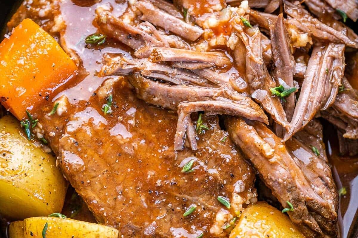cooked roast in sauce with potatoes and carrots.