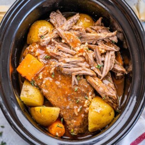 top view pot roast in a slow cooker with potatoes and carrots