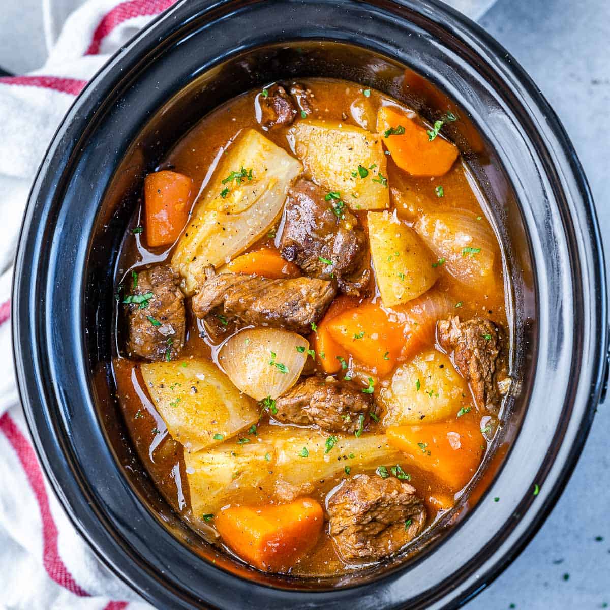 top view of beef stew in a black slow cooker dish