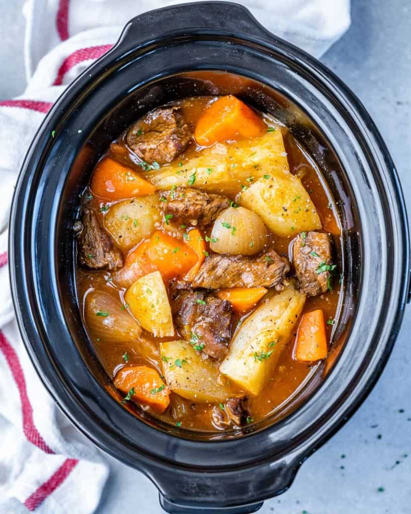 top view of Crockpot stew filled with onions, beef, carrots, and potatoes
