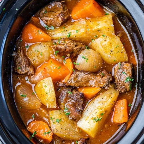 top view of carrots, potatoes, onions, and beef tips in broth inside Crockpot