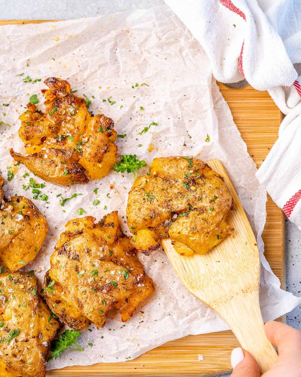 top view of smashed potatoes with wooden spoon 