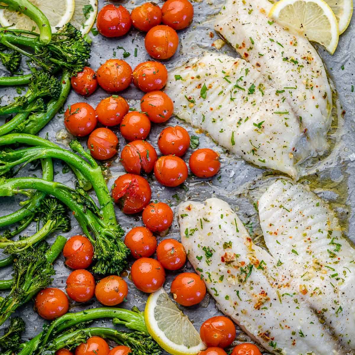 top view of baked tilapia with tomatoes and broccolini