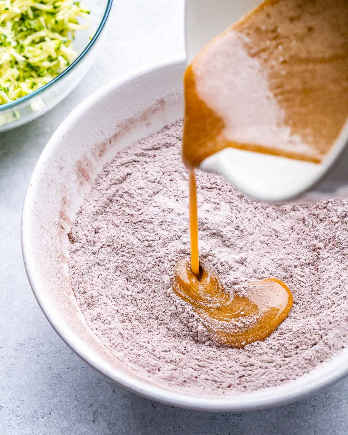 egg and oil liquid mixture being poured over the dry flour mixture