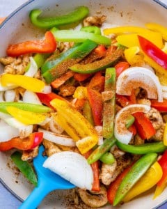 cooking the veggies with the fajita seasonings in a pan.