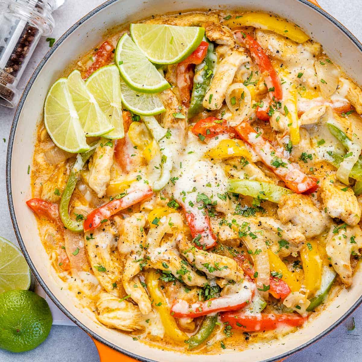 top view chicken fajitas in a skillet topped with cheese