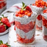 side shot of strawberry chia pudding in a jar, topped with more strawberries