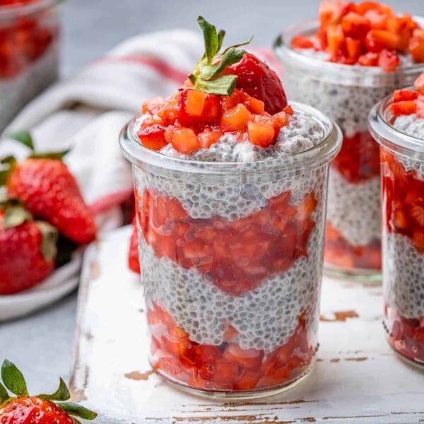 side shot of strawberry chia pudding in a jar, topped with more strawberries