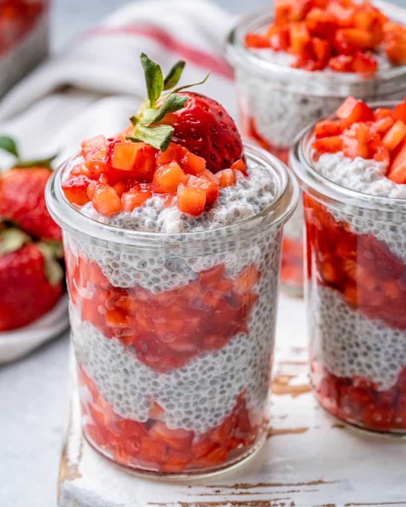 close up chia pudding with mashed fresh strawberries in a jar