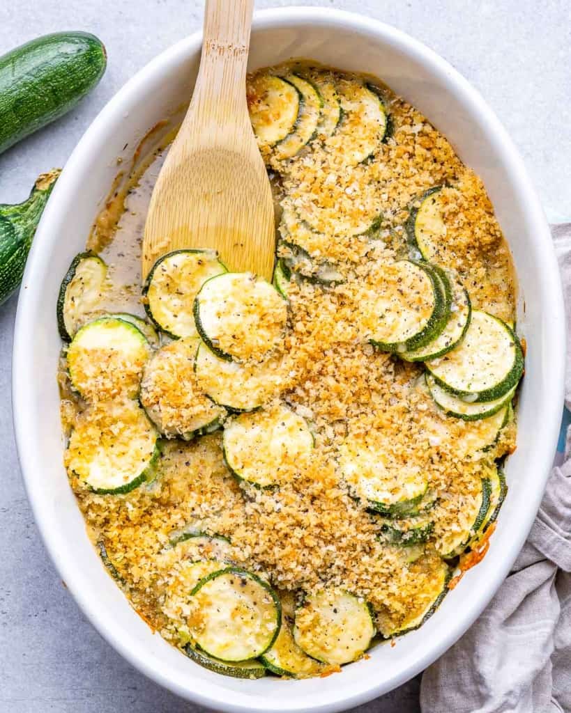 top view zucchini casserole dish with wooden spoon in it 
